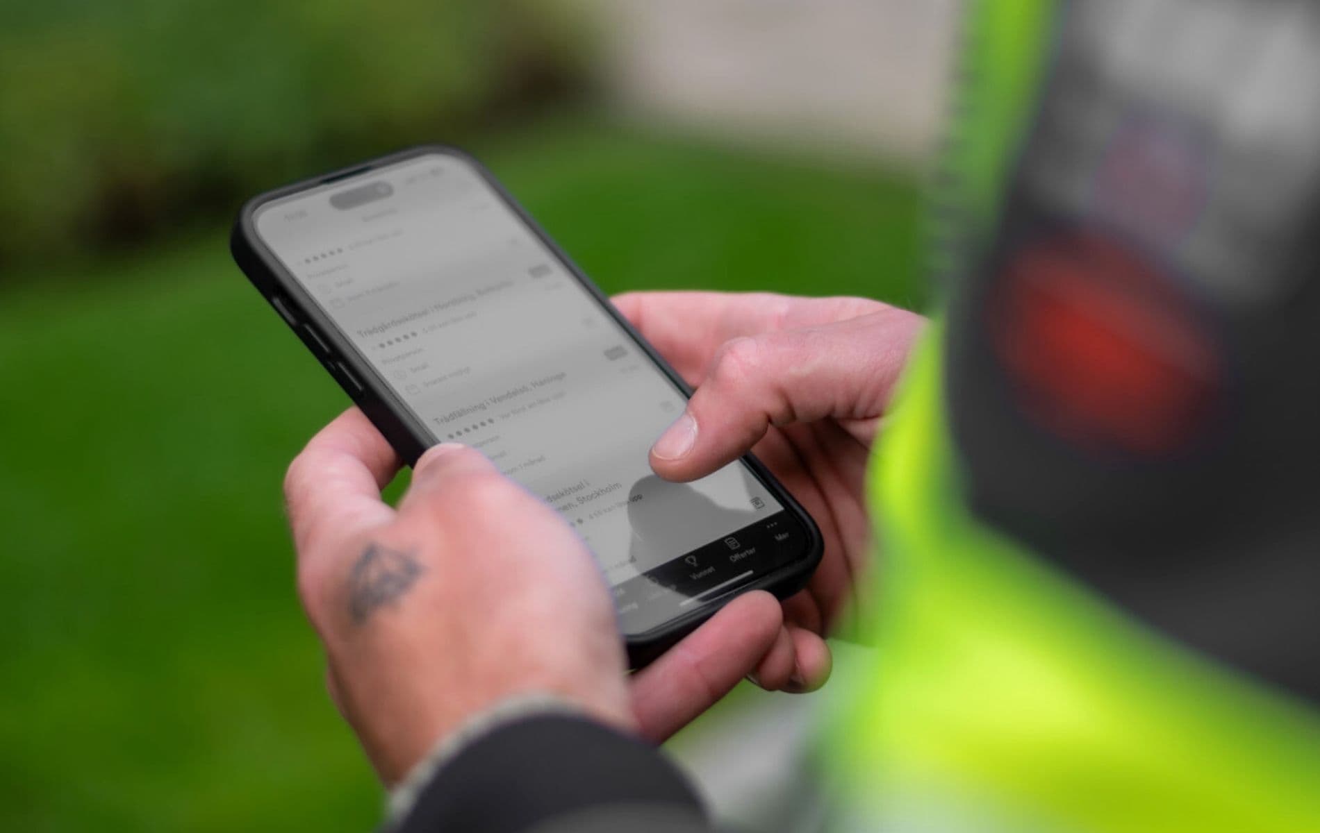 Hantverkare med varselkläder använder Offerta-appen