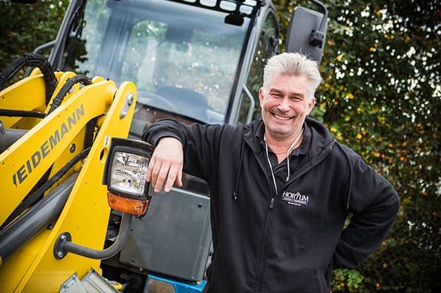 Ägaren till Hortum, verksamma inom tomt & mark, lutar sig mot traktor